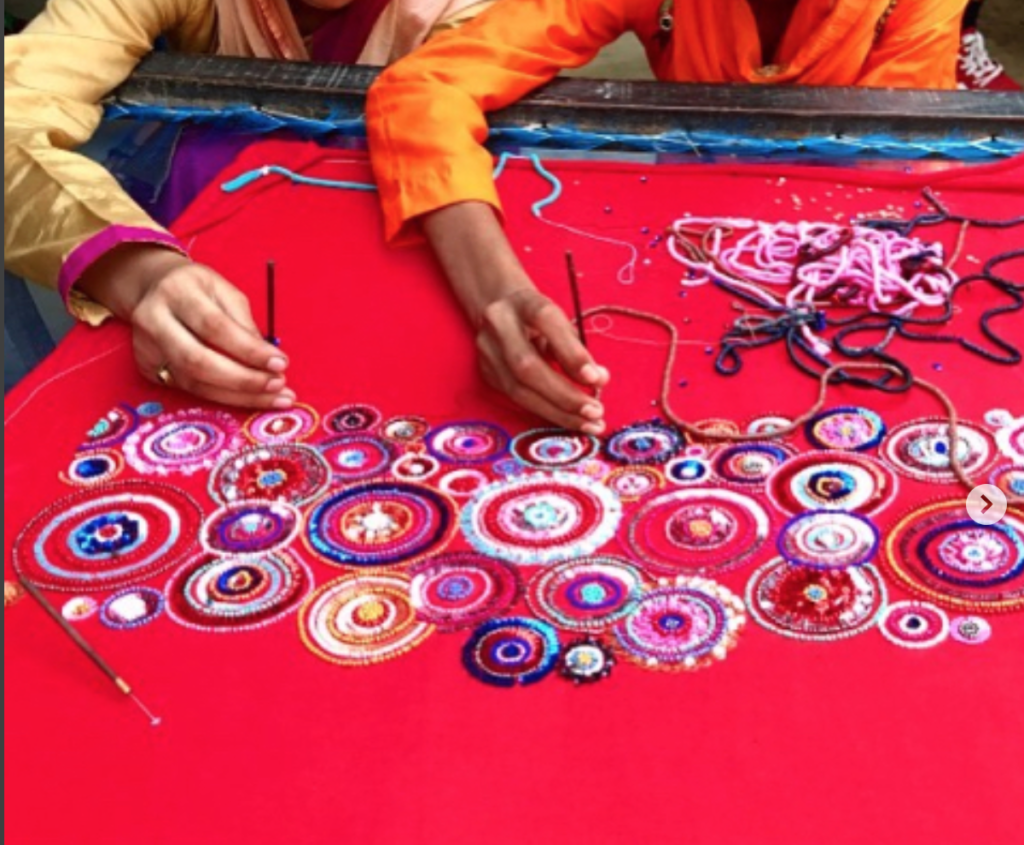 ENTITY reviews UNLEASHED's "Connecting Thread: Unleashing India" short. Picture of women beading fabric