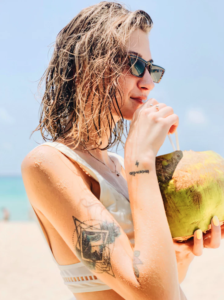 ENTITY shares image of girl drinking coconut via Unsplash