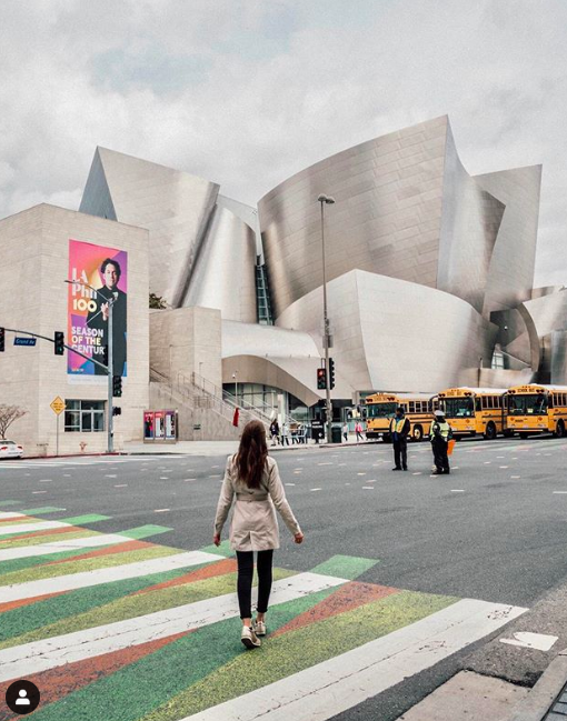 Entity shares photo of a woman walking towards Walt Disney concert hall