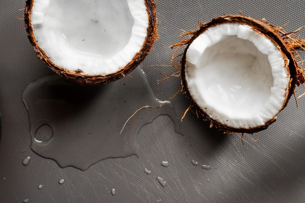 A photo of a coconut cut in half to reveal its water which is included in this brand's makeup. 