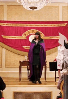 Gif of the Grand High Witch turning her cloak into a gown. Which Halloween Queen will you be based on your zodiac sign?