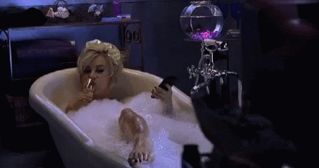 Gif of Tiffany in the bathtub with a glass of wine and TV remote. Halloween costume based on your zodiac sign, according to ENTITY Mag.