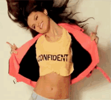 ENTITY Mag shares image of young woman in a shirt that says, "Confident" flipping her hair.