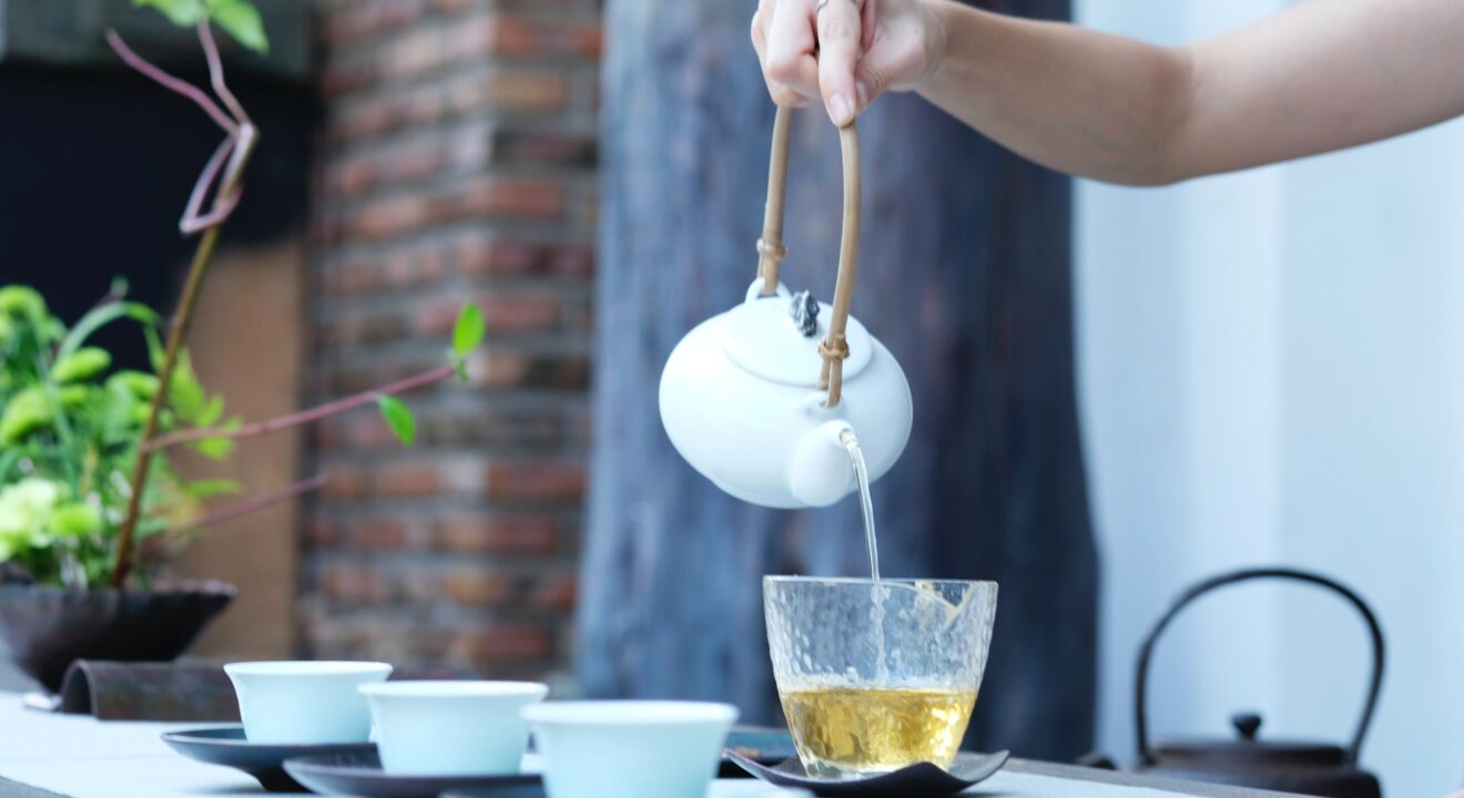Pot of tea being poured into a teacup